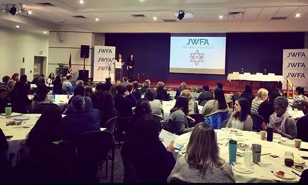 advocay-change2 JWFA event with a stage, podium and projector screen