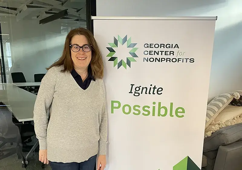 WLG at GCN Women's Leadership Grantee posing in front of a sign that says "GA Center for Nonprofits - Ignite Possible"